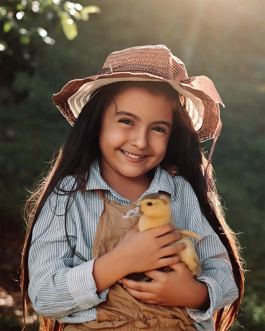 Retrato de niña con sombrero sosteniendo un pato